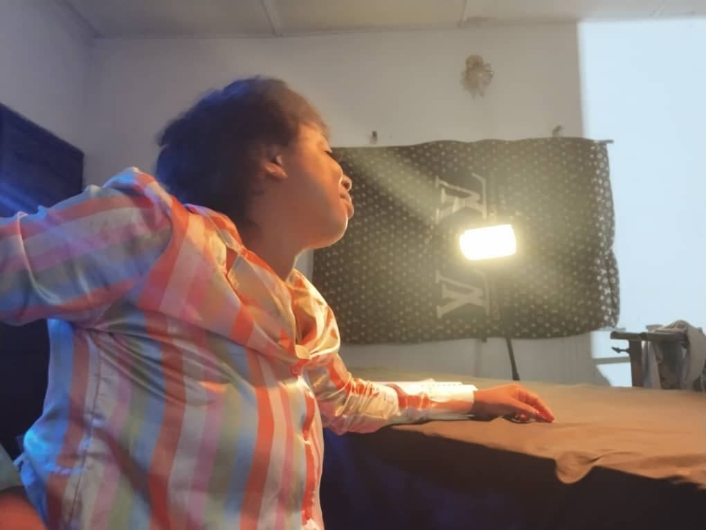 Actor performing beside a large studio light on an indoor set